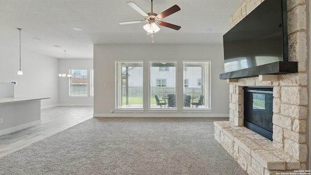 1606 Folk Victorian, New Braunfels, TX 78132 - unfurnished living room with a stone fireplace, ceiling fan, carpet flooring, and a chandelier