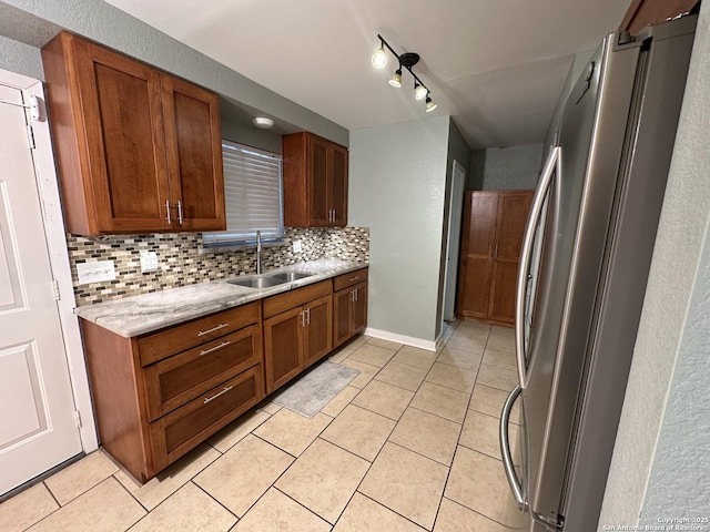105 W Silver Sands Unit 105A, San Antonio, TX 78216 - kitchen featuring freestanding refrigerator, backsplash, light tile patterned floors, brown cabinets, and a textured wall