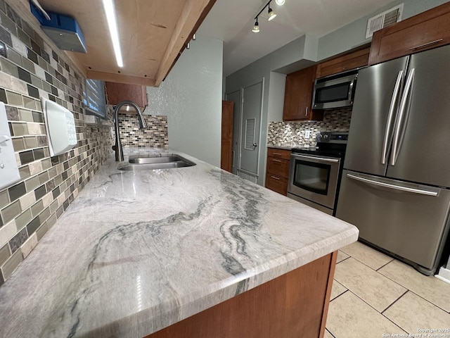 105 W Silver Sands Unit 105A, San Antonio, TX 78216 - kitchen with appliances with stainless steel finishes, backsplash, and light tile patterned flooring