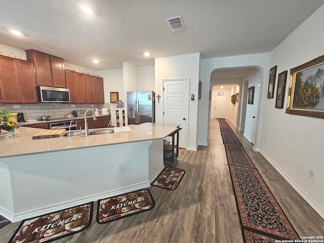 111 Lone Fls, Universal City, TX 78148 - kitchen featuring stainless steel appliances, dark wood-style floors, arched walkways, light countertops, and a textured ceiling