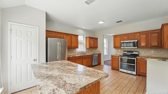 2166 Jolie, New Braunfels, TX 78130 - kitchen with stainless steel appliances, backsplash, light wood finished floors, brown cabinets, and recessed lighting