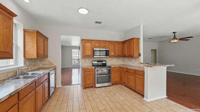 2166 Jolie, New Braunfels, TX 78130 - kitchen featuring stainless steel appliances, light wood-type flooring, ceiling fan, and backsplash