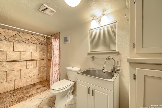 613 Drake Ave, San Antonio, TX 78204 - full bath featuring vanity, tiled shower, tile patterned flooring, and a textured ceiling