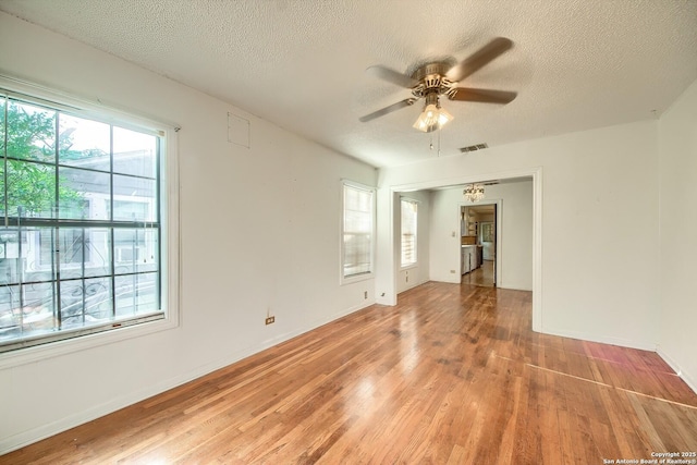 613 Drake Ave, San Antonio, TX 78204 - empty room with light wood-style floors, plenty of natural light, ceiling fan, and a textured ceiling