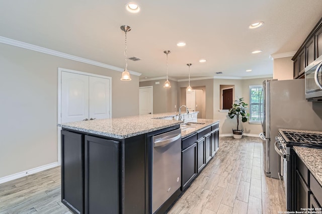 3354 Blossom Row, San Antonio, TX 78253 - kitchen featuring appliances with stainless steel finishes, an island with sink, light wood-type flooring, ornamental molding, and hanging light fixtures