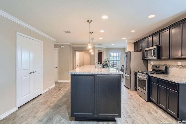 3354 Blossom Row, San Antonio, TX 78253 - kitchen featuring stainless steel appliances, crown molding, a center island with sink, light wood finished floors, and light stone countertops