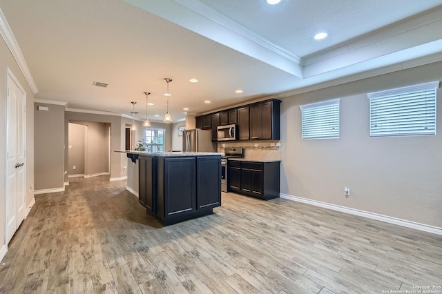 3354 Blossom Row, San Antonio, TX 78253 - kitchen featuring appliances with stainless steel finishes, crown molding, light wood-style flooring, a center island with sink, and hanging light fixtures