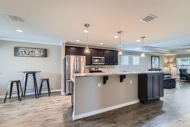 3354 Blossom Row, San Antonio, TX 78253 - kitchen with stainless steel appliances, ornamental molding, wood finished floors, a breakfast bar area, and recessed lighting
