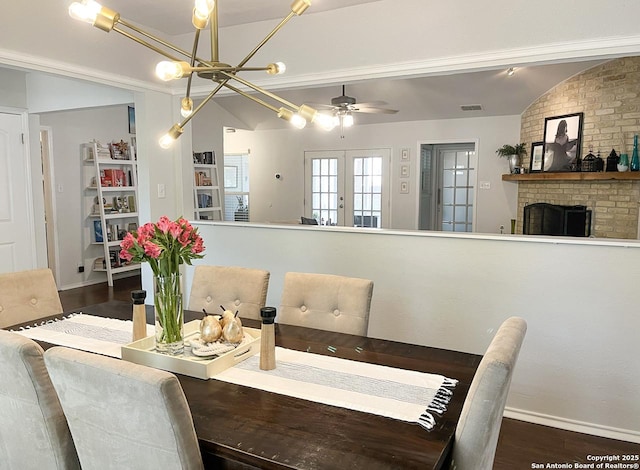 15115 Mission Oaks St, San Antonio, TX 78232 - dining space featuring wood finished floors, a ceiling fan, a chandelier, vaulted ceiling, and a fireplace