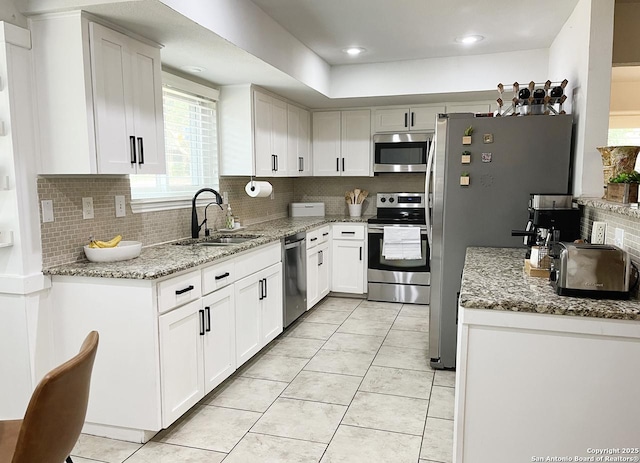 15115 Mission Oaks St, San Antonio, TX 78232 - kitchen featuring stainless steel appliances, decorative backsplash, light tile patterned flooring, and light stone countertops