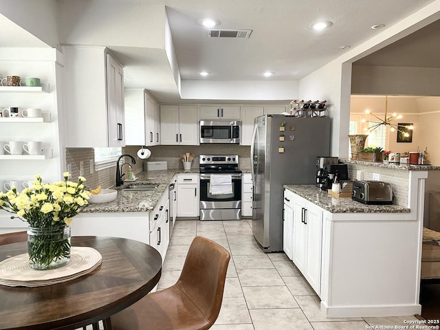 15115 Mission Oaks St, San Antonio, TX 78232 - kitchen featuring stainless steel appliances, a chandelier, light stone counters, light tile patterned floors, and white cabinets