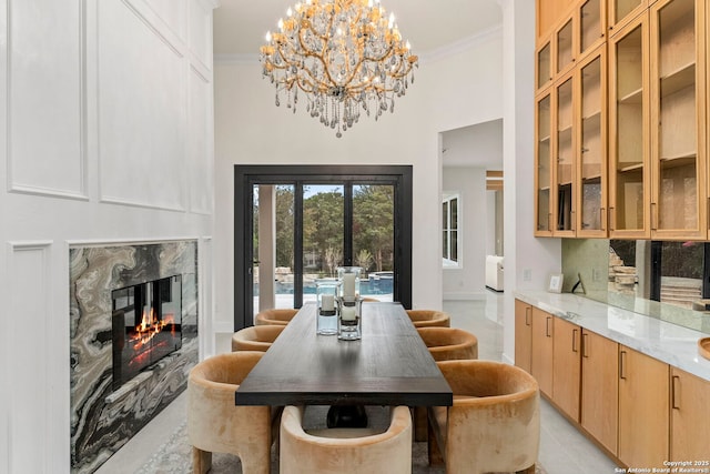 6 Turin Ct, San Antonio, TX 78257 - dining space featuring a high ceiling, crown molding, a chandelier, a high end fireplace, and light tile patterned floors