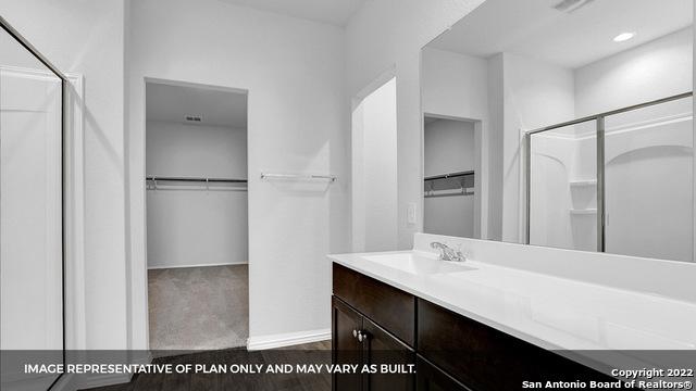 21039 Watercourse Way, San Antonio, TX 78266 - bathroom with a spacious closet, a shower stall, and vanity