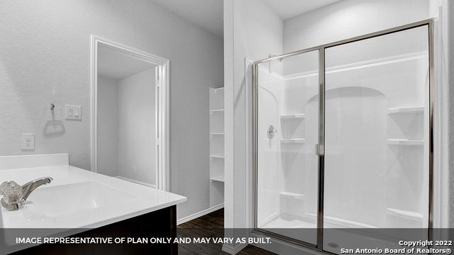 21039 Watercourse Way, San Antonio, TX 78266 - bathroom with a stall shower, vanity, and wood finished floors