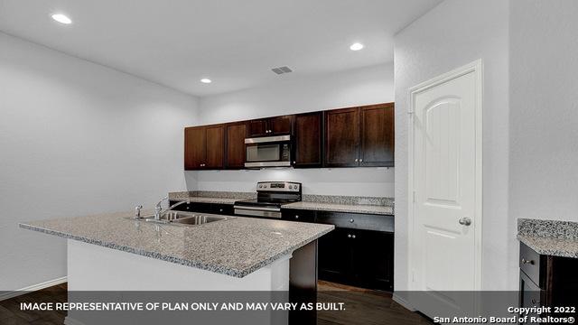 21039 Watercourse Way, San Antonio, TX 78266 - kitchen with stainless steel appliances, dark wood-style floors, light stone counters, dark brown cabinetry, and recessed lighting