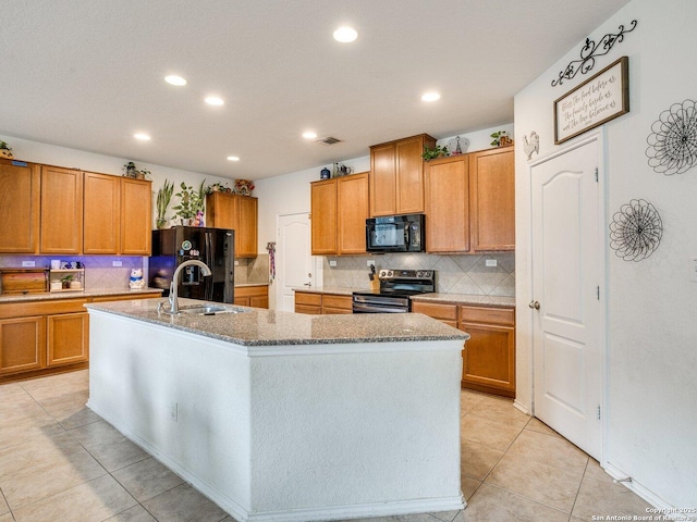 20127 Silver Strm, San Antonio, TX 78259 - kitchen with black appliances, an island with sink, recessed lighting, tasteful backsplash, and stone countertops