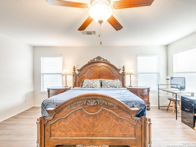 20127 Silver Strm, San Antonio, TX 78259 - bedroom with multiple windows, light wood finished floors, and a ceiling fan