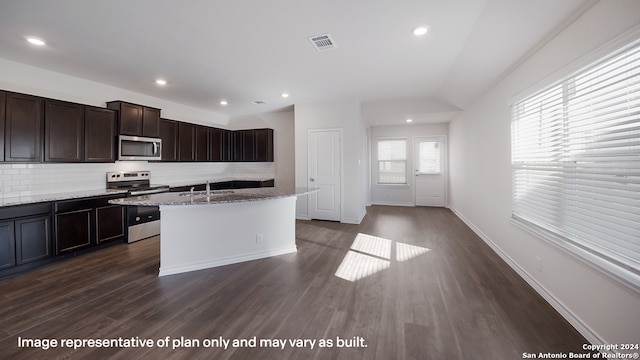 22716 Match Play, San Antonio, TX 78261 - kitchen with stainless steel appliances, tasteful backsplash, dark wood-style floors, a kitchen island with sink, and dark brown cabinets