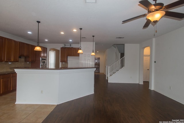4602 Manitou Bay, San Antonio, TX 78259 - kitchen featuring arched walkways, dark countertops, recessed lighting, a ceiling fan, and brown cabinetry