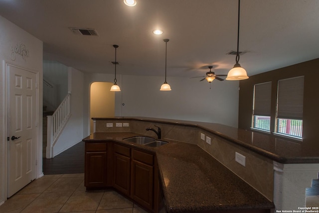 4602 Manitou Bay, San Antonio, TX 78259 - kitchen with light tile patterned flooring, a ceiling fan, dark stone counters, pendant lighting, and arched walkways