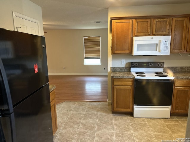 4606 Gambels Quail, Converse, TX 78109 - kitchen featuring white appliances, brown cabinetry, dark countertops, and light tile patterned floors