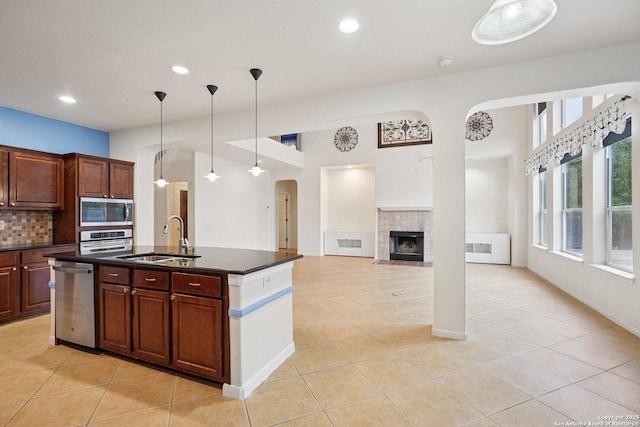 519 Catanbo, San Antonio, TX 78258 - kitchen featuring appliances with stainless steel finishes, dark countertops, arched walkways, light tile patterned floors, and recessed lighting