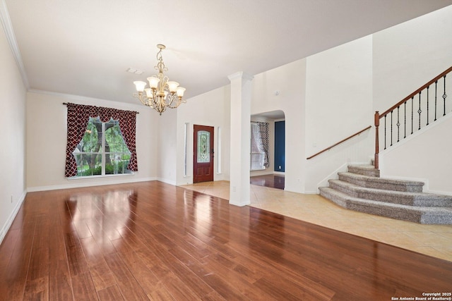519 Catanbo, San Antonio, TX 78258 - entryway featuring arched walkways, stairs, a chandelier, wood finished floors, and ornamental molding