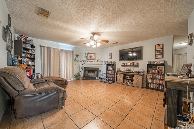 11002 Stagwood Pass, San Antonio, TX 78254 - living area with a fireplace, a ceiling fan, light tile patterned flooring, and a textured ceiling