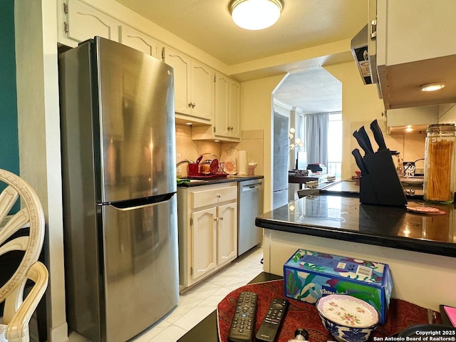 7039 San Pedro Ave Unit 601, San Antonio, TX 78216 - kitchen with appliances with stainless steel finishes, dark countertops, light tile patterned floors, and backsplash
