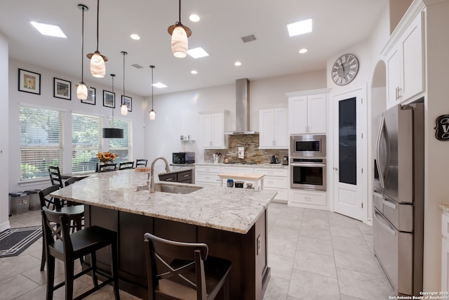 26130 Sunny Mdw, San Antonio, TX 78260 - kitchen featuring stainless steel appliances, wall chimney range hood, a large island with sink, decorative backsplash, and a breakfast bar