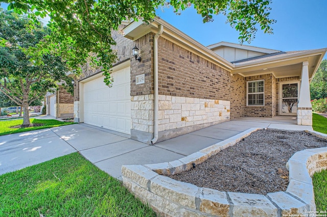 13059 Cache, San Antonio, TX 78253 - view of home's exterior with an attached garage, driveway, brick siding, board and batten siding, and stone siding