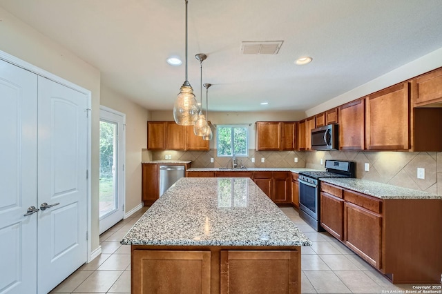 13059 Cache, San Antonio, TX 78253 - kitchen with appliances with stainless steel finishes, brown cabinets, light tile patterned floors, light stone counters, and recessed lighting