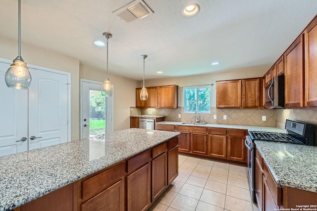 13059 Cache, San Antonio, TX 78253 - kitchen featuring stainless steel appliances, brown cabinetry, light stone counters, and recessed lighting