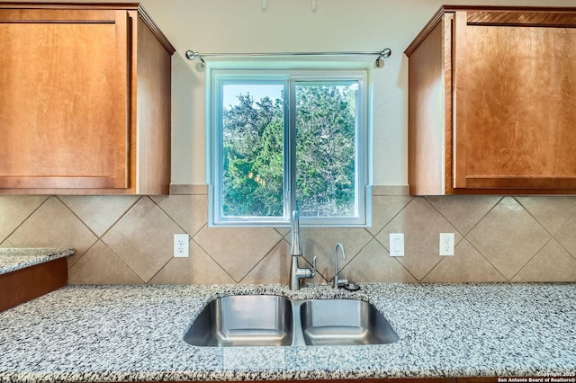 13059 Cache, San Antonio, TX 78253 - kitchen featuring light stone countertops, brown cabinets, and decorative backsplash