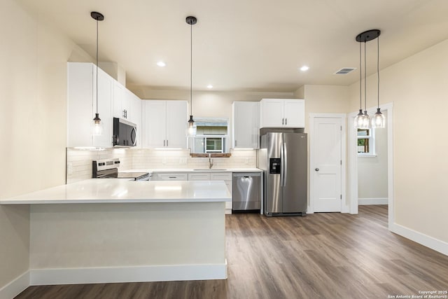302 Riley Way, Kerrville, TX 78028 - kitchen with appliances with stainless steel finishes, tasteful backsplash, dark wood-style floors, light countertops, and a peninsula