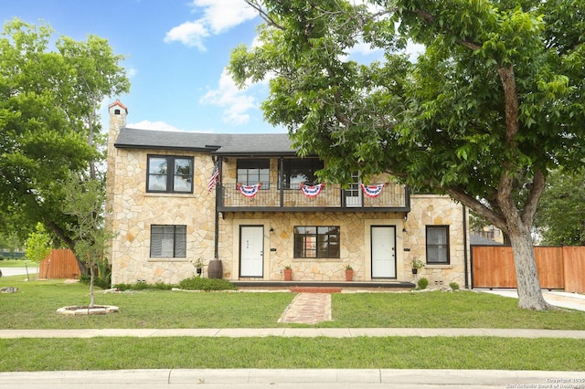 1002 Kampmann Blvd, San Antonio, TX 78201 - view of front of house with a balcony, stone siding, a chimney, and roof with shingles