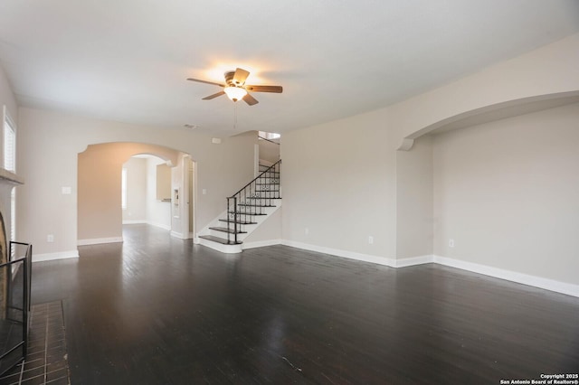 1002 Kampmann Blvd, San Antonio, TX 78201 - unfurnished living room with a ceiling fan, dark wood-style flooring, stairs, and arched walkways