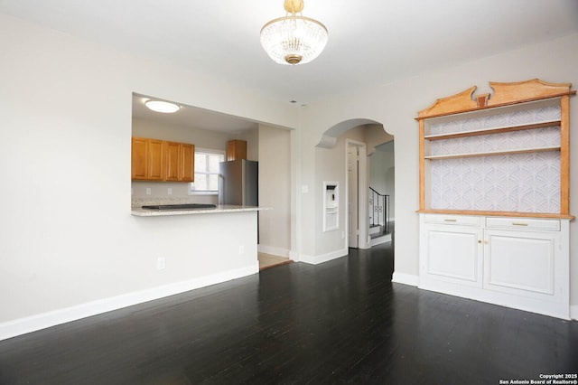 1002 Kampmann Blvd, San Antonio, TX 78201 - unfurnished living room with arched walkways, dark wood finished floors, and stairway