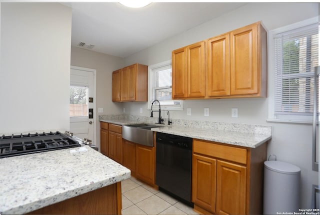1002 Kampmann Blvd, San Antonio, TX 78201 - kitchen with dishwasher, light tile patterned flooring, and light stone counters