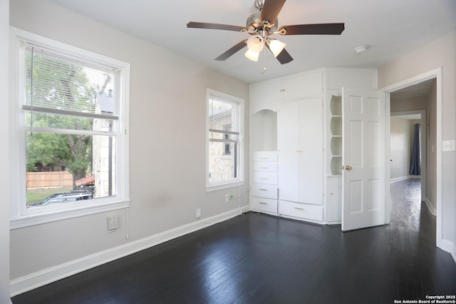 1002 Kampmann Blvd, San Antonio, TX 78201 - unfurnished bedroom with multiple windows, dark wood finished floors, and a ceiling fan