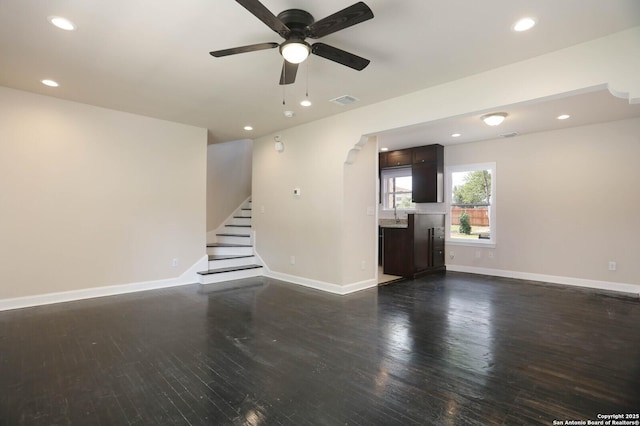 1002 Kampmann Blvd, San Antonio, TX 78201 - unfurnished living room featuring a ceiling fan, dark wood-type flooring, recessed lighting, stairway, and arched walkways