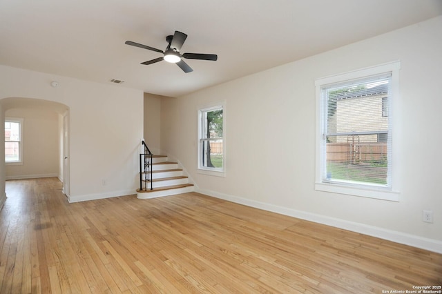 1002 Kampmann Blvd, San Antonio, TX 78201 - spare room with arched walkways, stairs, light wood-type flooring, and ceiling fan