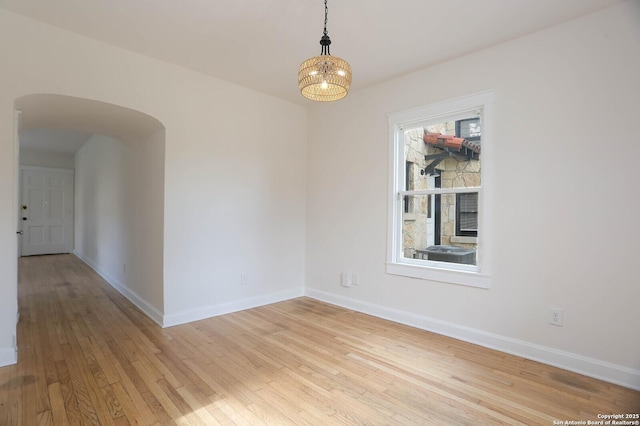 1002 Kampmann Blvd, San Antonio, TX 78201 - unfurnished room featuring arched walkways, light wood-style flooring, and a chandelier