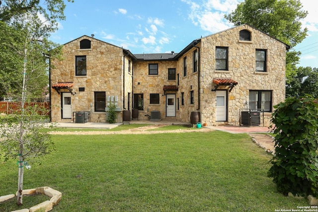 1002 Kampmann Blvd, San Antonio, TX 78201 - back of house with stone siding, a patio, and a lawn