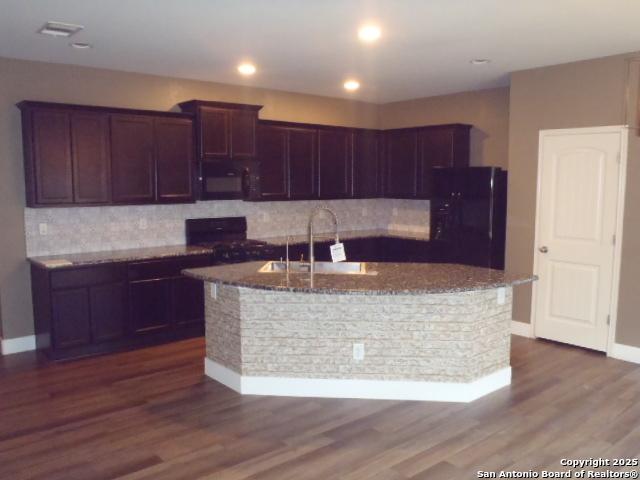 2690 Mccrae, New Braunfels, TX 78130 - kitchen featuring black microwave, fridge, decorative backsplash, dark stone counters, and range