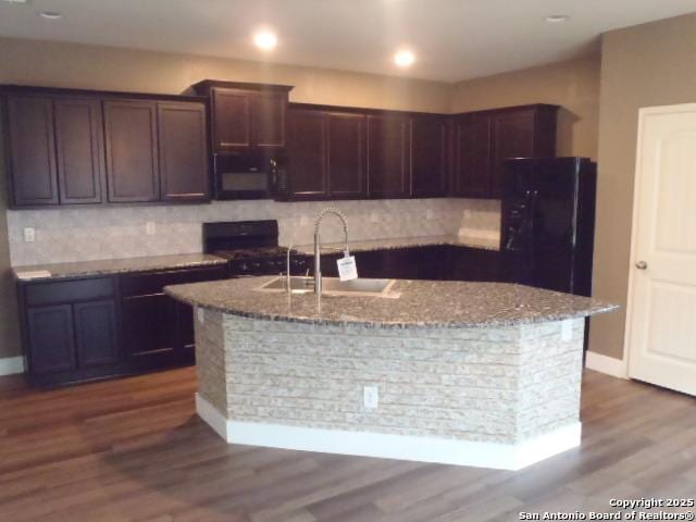2690 Mccrae, New Braunfels, TX 78130 - kitchen featuring black appliances, light stone counters, tasteful backsplash, and an island with sink