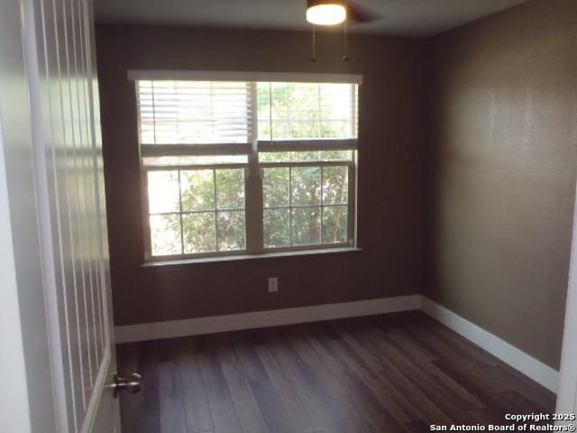 2690 Mccrae, New Braunfels, TX 78130 - empty room with dark wood-style floors, ceiling fan, and plenty of natural light