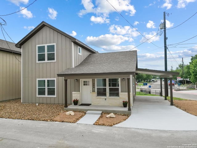 304 Riley Way, Kerrville, TX 78028 - view of front facade with a shingled roof, concrete driveway, an attached carport, board and batten siding, and covered porch