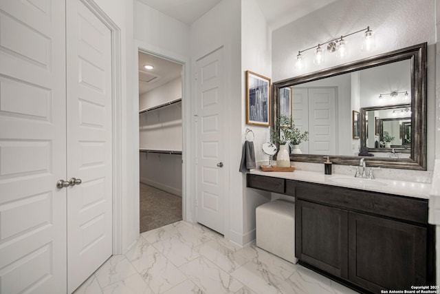 270 Lily Pass, Castroville, TX 78009 - bathroom with marble look tile flooring, vanity, and a spacious closet