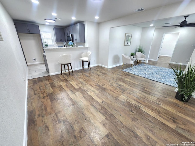 102 Wonder, San Antonio, TX 78213 - kitchen with dark wood-type flooring, stainless steel microwave, a breakfast bar, light countertops, and open floor plan